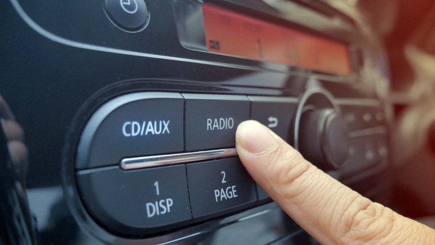 Person pushing radio button in car