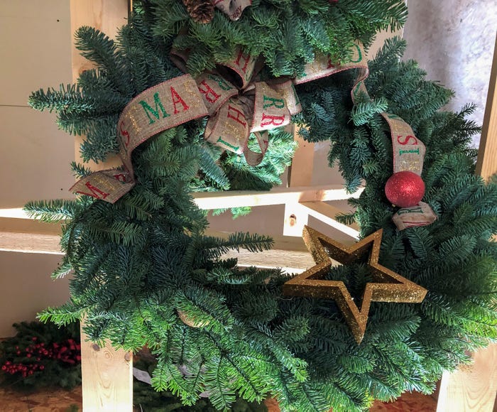 A fresh cut wreath with ribbon and glitter ornaments
