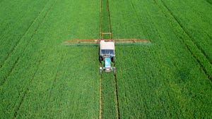 Aerial view of a tractor spraying a crop field