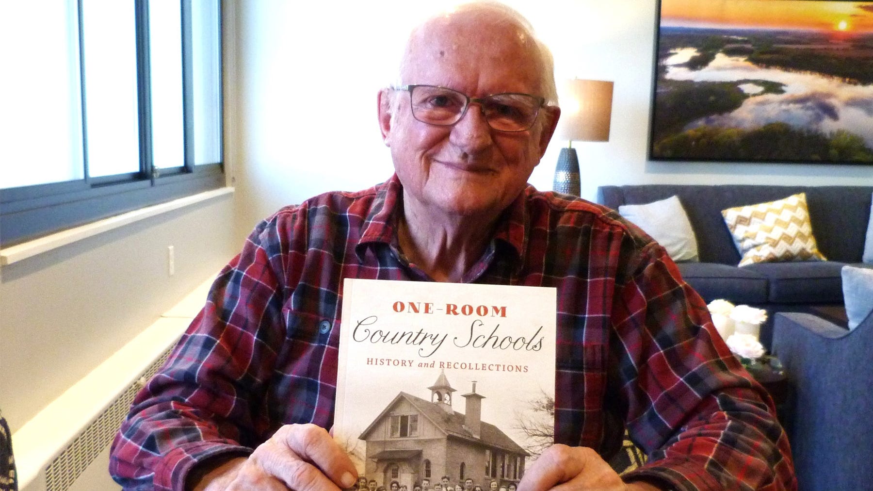 Jerry Apps holding book about one-room country schools