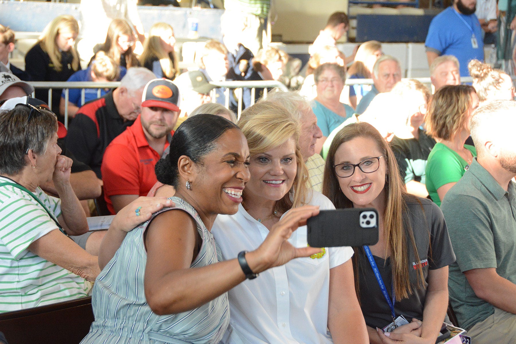 3 women taking a selfie in a crowd of people
