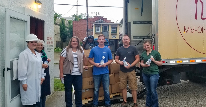 A group of people making a food donation courtesy of Heimerl Farms
