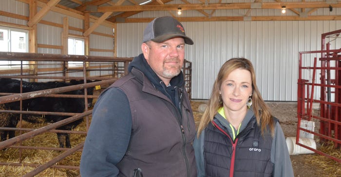 Scott and Jenni Birker stand inside their rebuilt calving barn