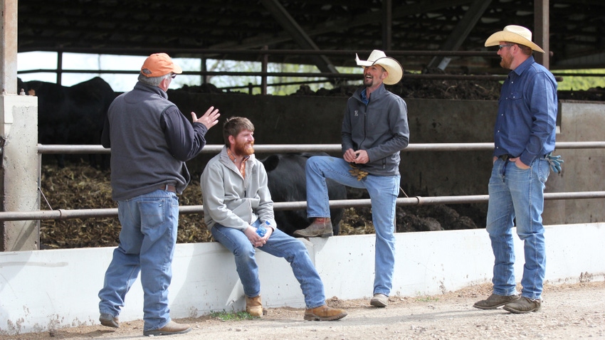 Larry O’Hern, Dan O’Hern, Matt Taylor and Lawrence Knott talk while standing outside cattle barn