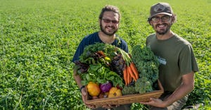 Robert “Bobcat” Bonagura and Allan Gandelman hold up a basket of fresh produce