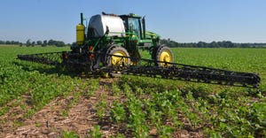 Applicator spraying soybean field