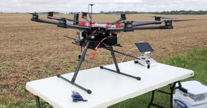 drone on table in field with chemicals to apply to field