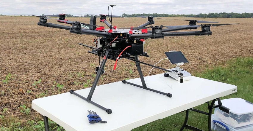 drone on table in field with chemicals to apply to field