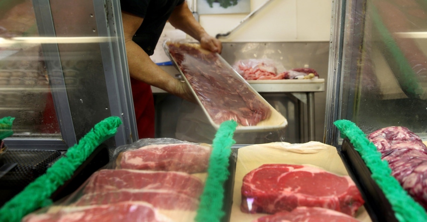 Man restocking beef in a butcher shop