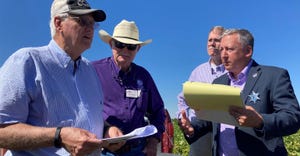 Farmer Richard Wenstrom, left, speaks with K-State President Richard Linton in his soybean field south of Kinsley, Kan., Sept