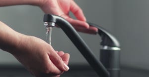 Hands and faucet with running water