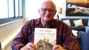 Jerry Apps holding his book about one-room schools