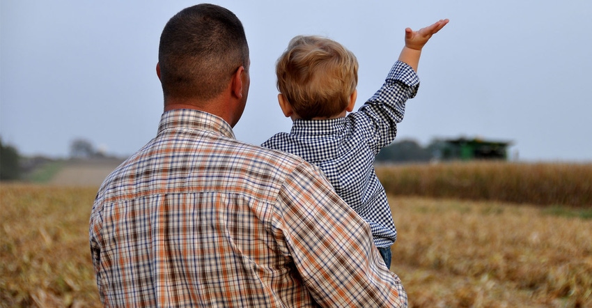 father and son standing in field father and son standing in field
