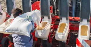 man loading soybean seats into planter