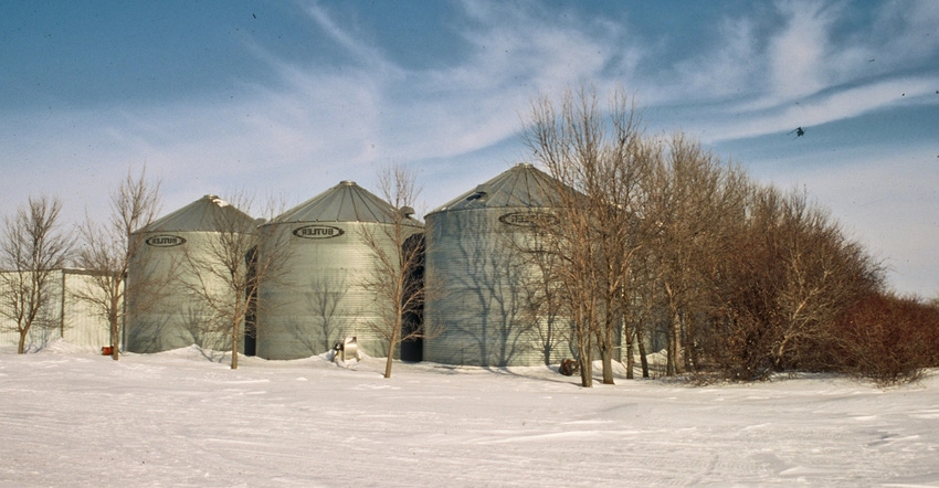 row of steel grain bins in snow