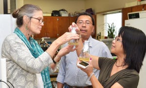 Susan McCouch of Cornell University, left, examines work being done by LSU AgCenter researchers Herry Utomo, center, and Ida Wenefrida in a laboratory at the LSU AgCenter Rice Research Station. (Photo by Bruce Schultz, LSU AgCenter)