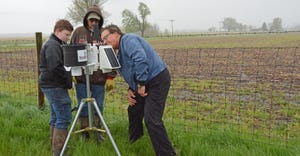 Mike Thurow sets up a weather station on John Spangler’s farm