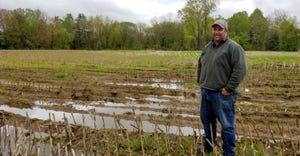 Neil Peck stands in his unplanted corn field due to the wet spring