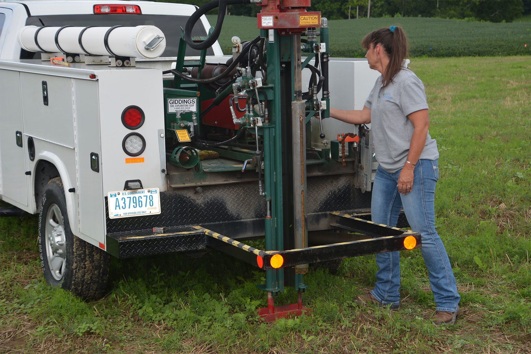 woman stands next to truck with a hydraulic probe for pulling soil sample cores woman stands next to truck with a hydraulic probe for pulling soil sample cores