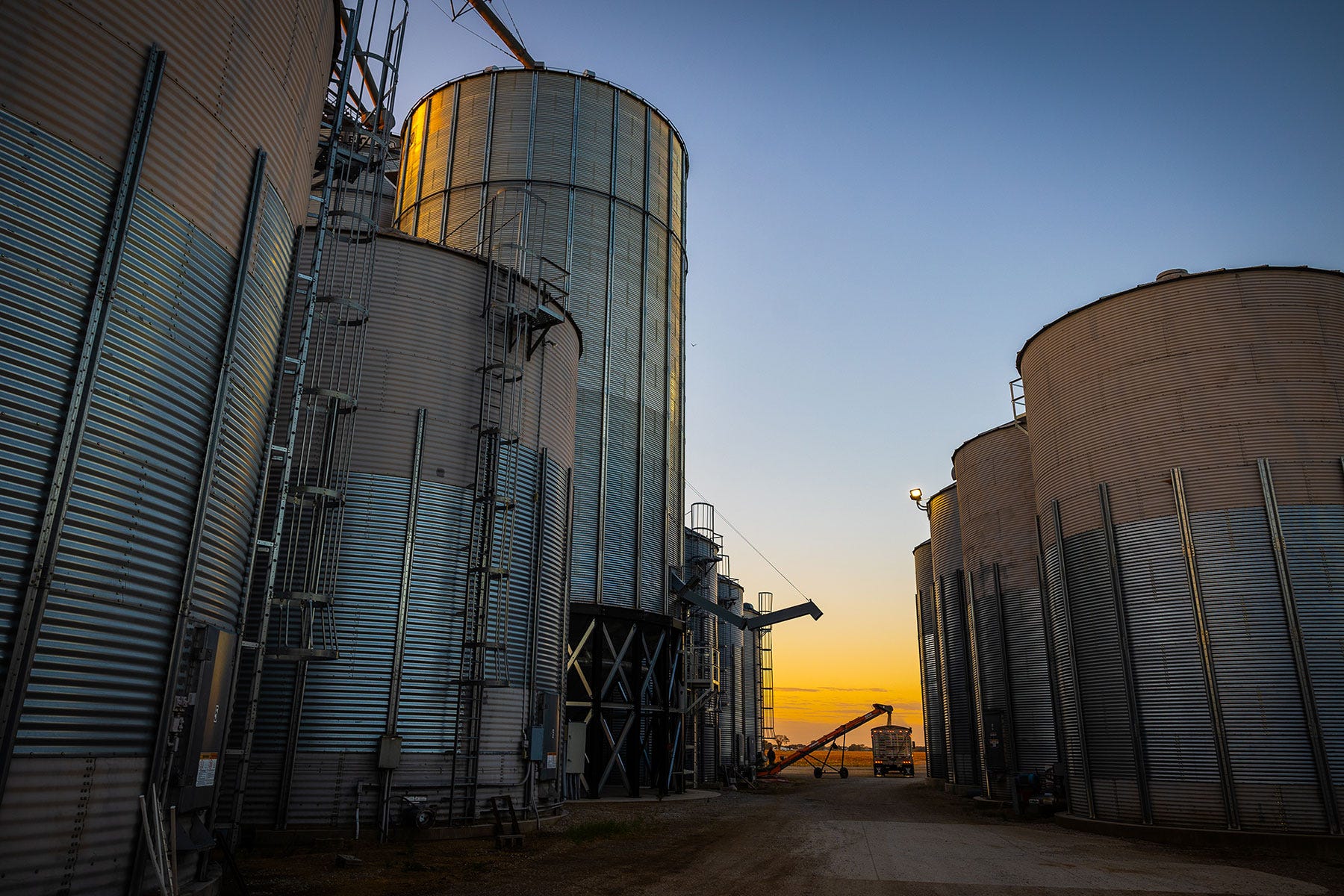 view between grain bins at sunrise