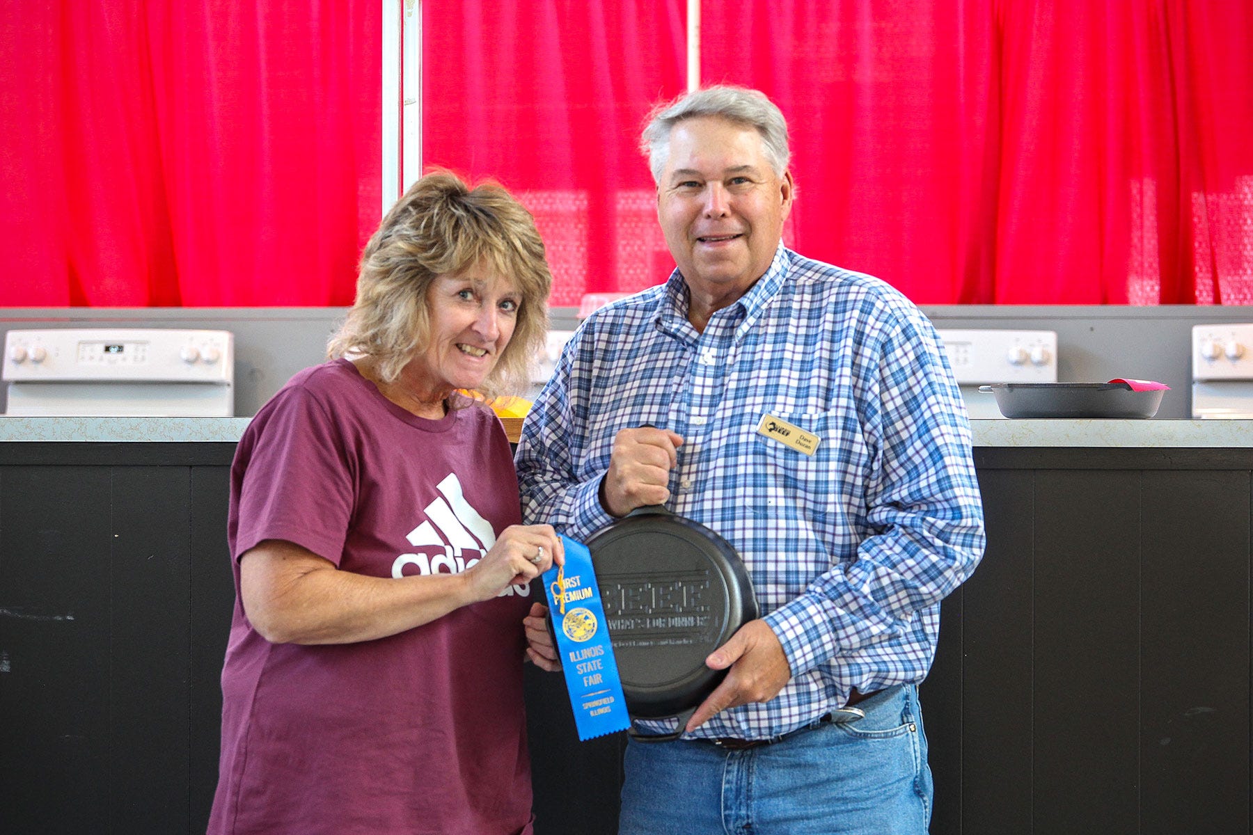 A woman handing Dave Duzan, Illinois Beef Association president, a ribbon award