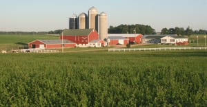 Wisconsin dairy farmstead with red farm buildings, grain silos and white house