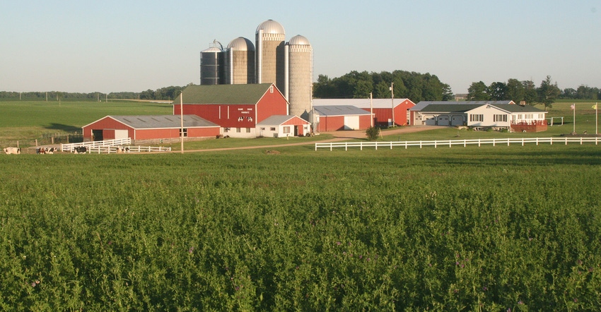Wisconsin dairy farmstead with red farm buildings, grain silos and white house