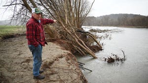 Dave Conant stands near an eroding riverbank
