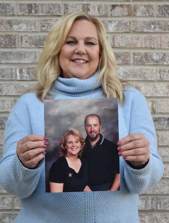 Melissa Huff holding a photo of her with her late husband, Rich
