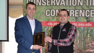 Jason Hartschuh, vice chairman of the Ohio CCA Board (right), presents Dr. Alex Lindsey with the 2023 Ohio Ce