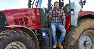 farmer sitting on tractor talking on cell phone
