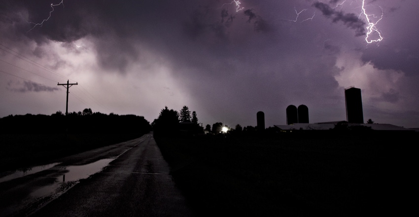 Farmstead during lightning storm at night