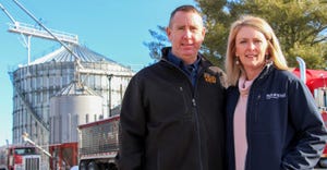 Doug and Christy Aylward pose in front of grain bins