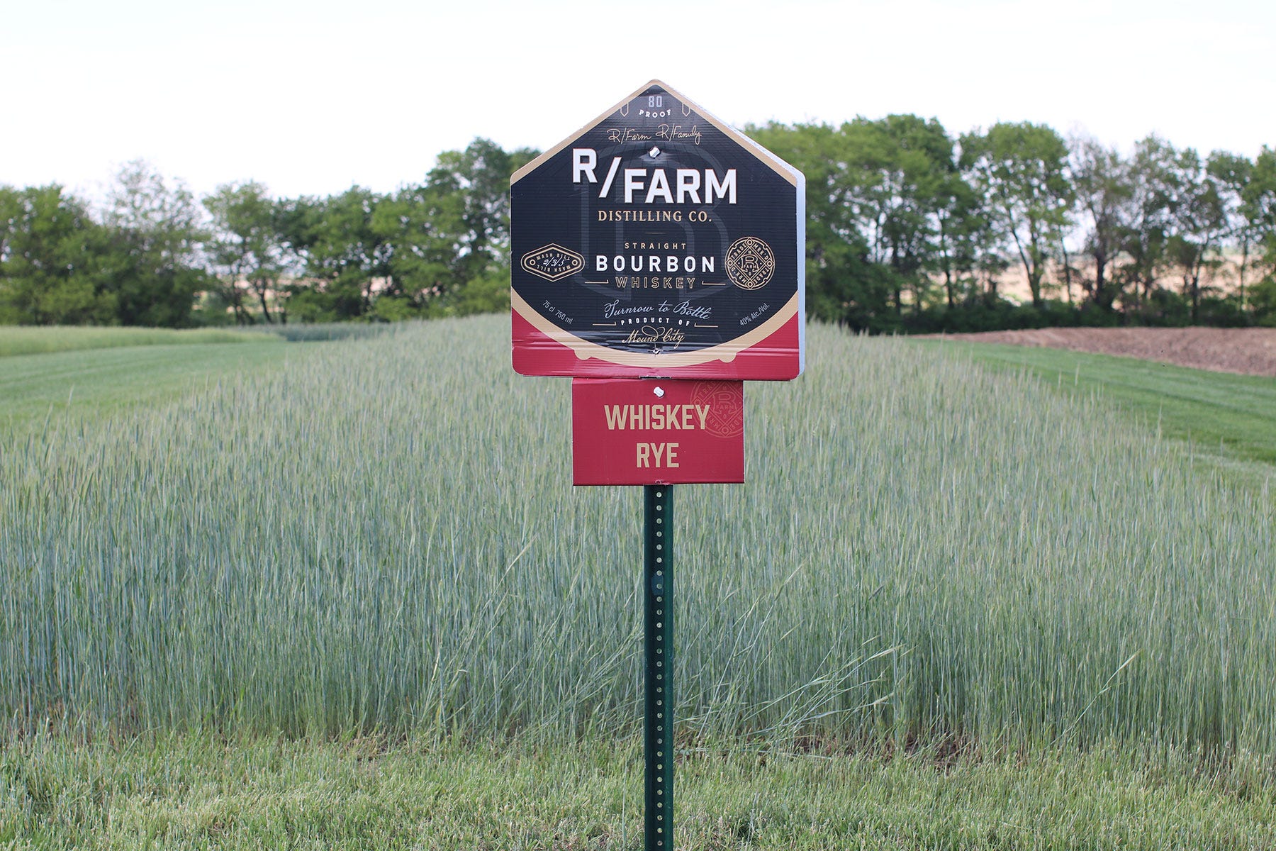 An R/Farm sign in front of a rye field