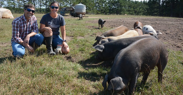 Joshua and Alison Stamper pose with some of their heritage pigs