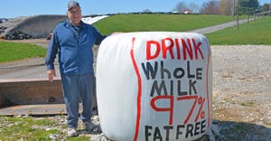 Nelson Troutman stands proudly next to one of his newest 97 milk bales he painted on the farm
