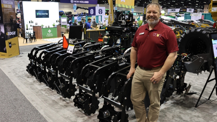 Tyler Fickenscher stands with a SoilWarrior Edge strip-till tool at Commodity Classic