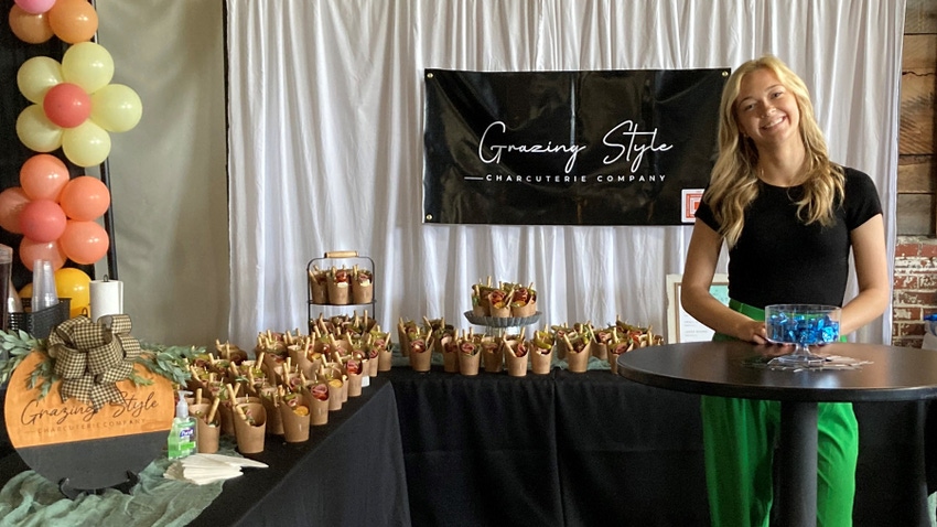 Rachel Holkenbrink shows off her Grazing Style Charcuterie Company booth filled with goodies