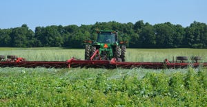 machinery crimping cover crops growing in field