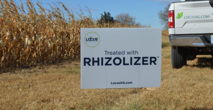 Treated with RHIZOLIZER sign infront of corn field.