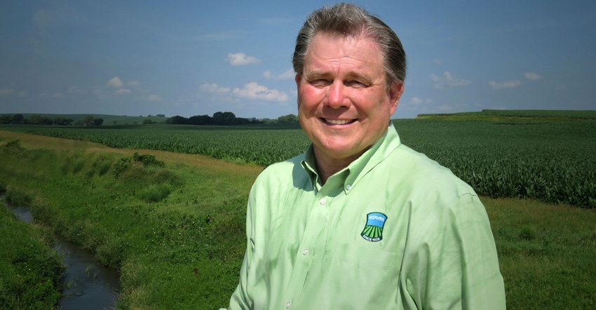 Dennis Reyman standing in a field by an open ditch with green buffer