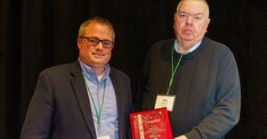Brad Ponsler, left, receives a plaque for IASWCD Supervisor of the Year from Tom J. Bechman