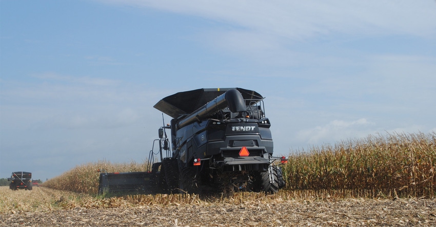 Combine harvesting corn in field