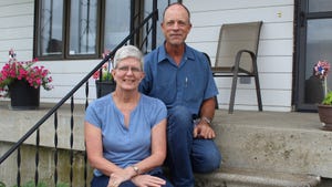 Jane and Phil Halling sitting on stairs to front porch of house