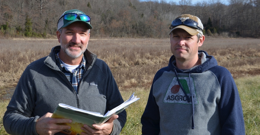 Kyle Turpin, right, and Mark Cambron review plans for the conservation projects completed on Turpin’s farm 