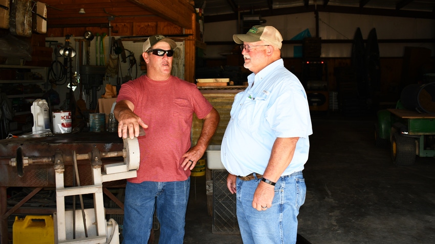 Two men standing in a shop talking.