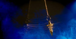 Pendulum used for hypnotism and readings swinging with motion blur