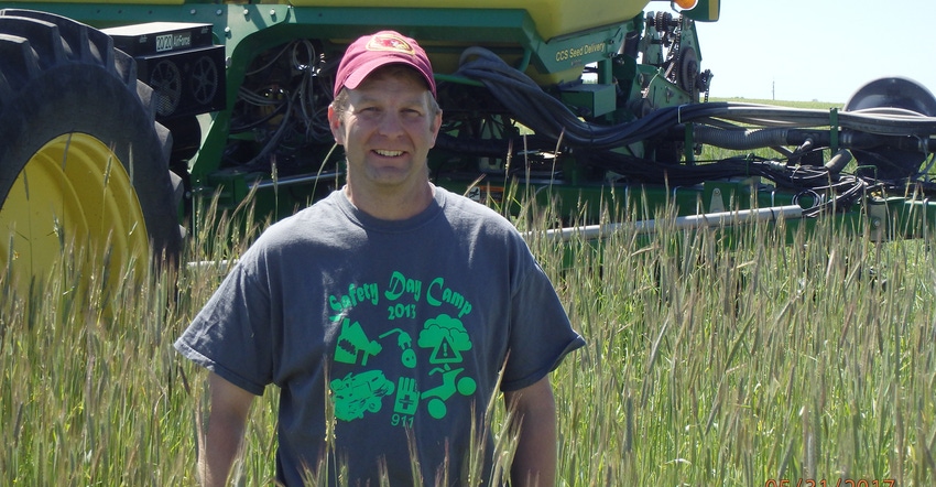 Doug Adams stands in his soybean field among a tall cereal rye cover crop