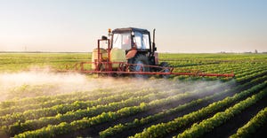 A tractor spraying a soybean field