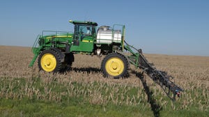 Tractor applying herbicide in field